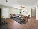 Bright living room with a ceiling fan, wood-look flooring, and contemporary decor creates a warm, inviting space at 10739 Se 44Th Ter, Belleview, FL 34420