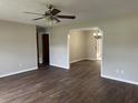 Spacious living room featuring new wood floors, ceiling fan, and an open archway at 10739 Se 44Th Ter, Belleview, FL 34420