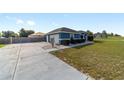 Side view of a blue single-story home featuring an attached garage and a long driveway at 13115 Sw 49Th Ave, Ocala, FL 34473
