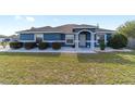 Charming blue single-story home with manicured landscaping, decorative rock, and an inviting entrance at 13115 Sw 49Th Ave, Ocala, FL 34473