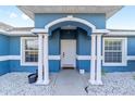 Inviting front porch with white columns and an arched entrance, enhancing curb appeal at 13115 Sw 49Th Ave, Ocala, FL 34473