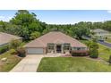 Aerial view of a single-story home featuring a manicured lawn, mature trees, and a private driveway at 15 Sunrise Dr, Ocala, FL 34472