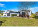 Beautifully landscaped home featuring a lush lawn, manicured shrubs, and a side-entry garage enhancing curb appeal at 15825 Sw 11Th Court Rd, Ocala, FL 34473