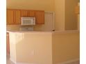 Bright kitchen featuring wooden cabinets, white countertops, and a microwave oven at 1754 Sw 160Th Pl, Ocala, FL 34473