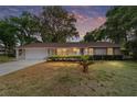 Charming single-story home with a well-manicured lawn and mature trees at sunset at 2220 Ne 41St St, Ocala, FL 34479