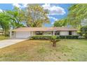Charming single-story home with a well-manicured lawn and mature trees at 2220 Ne 41St St, Ocala, FL 34479