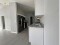 Modern kitchen with white cabinetry, granite countertops, stainless steel appliances, and tile flooring at 28 Bahia Pass Dr, Ocala, FL 34472