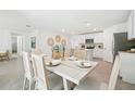 Open dining area features neutral decor, table set for six, and easy access to kitchen and living spaces at 4746 Sw 88Th Ln, Ocala, FL 34476