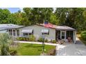 Inviting single-story home with a lush green lawn, complemented by mature trees and a stately American flag at 514 Saint Andrews Blvd, Lady Lake, FL 32159