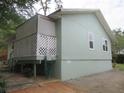 Exterior view showcasing the side of the house and covered patio area at 5949 Se 164Th Ct, Ocklawaha, FL 32179