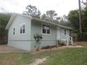 Well-maintained single-story home with a neutral color scheme, landscaped yard, and mature trees at 5949 Se 164Th Ct, Ocklawaha, FL 32179