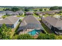 Aerial view of home with screened-in pool, landscaped yard, and surrounding neighborhood with a lake at 6394 Sw 97Th Terrace Rd, Ocala, FL 34481