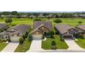 Aerial view of a home with a well-manicured lawn surrounded by lush greenery in a beautiful community at 6868 Sw 95Th Cir, Ocala, FL 34481