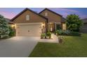 Charming home featuring a two-car garage, stone accents, a covered entry, and manicured landscaping at 6868 Sw 95Th Cir, Ocala, FL 34481