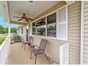 Inviting front porch features a ceiling fan and plenty of space for relaxing at 8140 Sw 109Th Street Rd, Ocala, FL 34481
