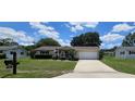 Well-maintained home with an attached garage, neat lawn, and welcoming front porch and entry at 8244 Sw 106Th Pl, Ocala, FL 34481