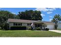 Inviting single-story home featuring a well-kept lawn, an American flag, and a cozy front porch at 8244 Sw 106Th Pl, Ocala, FL 34481