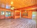 Expansive living area with wood-paneled walls, laminate flooring, and built in shelving at 834 Ne 10Th Ave, Ocala, FL 34470