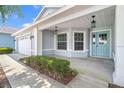 Inviting home front featuring a charming light blue front door and well-maintained landscaping at 9287 Sw 91St Court Rd, Ocala, FL 34481