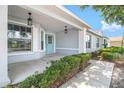 Inviting front porch with decorative hanging lights and freshly trimmed shrubs adds to the home's curb appeal at 9287 Sw 91St Court Rd, Ocala, FL 34481