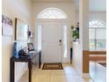 Bright foyer with a decorative table, neutral tile flooring, and a view of the front door at 9677 Sw 56Th Cir, Ocala, FL 34476