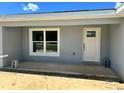 New construction home featuring a glass-paneled front door and large picture window at 1057 Nw 68Th Pl, Ocala, FL 34474