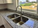 Kitchen featuring a stainless steel sink, granite countertops, and a large window overlooking the yard at 1057 Nw 68Th Pl, Ocala, FL 34474