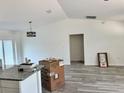 Bright and airy living room with modern lighting, gray wood-look flooring, and white walls at 1057 Nw 68Th Pl, Ocala, FL 34474