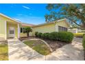 The side exterior of a yellow home with manicured landscaping along the sidewalk and front facade at 11245 Sw 63Rd Terrace Rd, Ocala, FL 34476