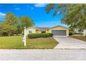 Inviting single-Gathering home with a lush green lawn, mature trees, and a screened two-car garage at 11245 Sw 63Rd Terrace Rd, Ocala, FL 34476