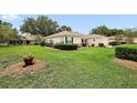 Well-maintained front yard featuring green grass, manicured shrubbery, and a charming single-story home at 13786 Se 88Th Ct, Summerfield, FL 34491