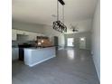 Spacious open-concept with modern light fixture and gray tile flooring at 15419 Sw 65Th Terrace Rd, Ocala, FL 34473