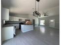 Open-concept living room and kitchen with gray tile flooring and modern lighting fixtures at 15419 Sw 65Th Terrace Rd, Ocala, FL 34473