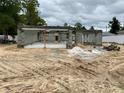 Construction site shows block walls being built for a new house on a sandy lot under a cloudy sky at 15833 Se 97Th Ter, Summerfield, FL 34491