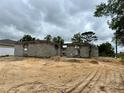 Ongoing house construction showing concrete blocks with a cloudy sky backdrop on a sandy lot at 15833 Se 97Th Ter, Summerfield, FL 34491