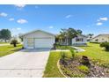 Well-maintained home features a clean driveway, attached garage, and landscaped garden beds on a sunny day at 17915 Se 102Nd Ter, Summerfield, FL 34491