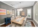 Stylish dining room with chandelier, hardwood floors, and gray walls at 1906 Se 28Th Pl, Ocala, FL 34471