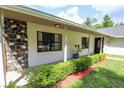 Inviting covered porch with stone accents, neat landscaping, and an elegant front door at 2406 Se 40Th Street Rd, Ocala, FL 34480