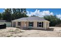 Charming home showcasing neutral siding, black shutters, new roof, and convenient attached carport at 24128 Sw South Lakes Ct, Dunnellon, FL 34431