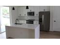 Modern kitchen with stainless steel appliances, white cabinets, and a large center island at 2438 Sw 165Th Street Rd, Ocala, FL 34473