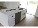 Kitchen island featuring a sink, dishwasher, white cabinets and a solid countertop at 2438 Sw 165Th Street Rd, Ocala, FL 34473
