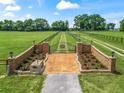 Gated entrance featuring decorative brickwork and landscaping, leading to a long private driveway and sprawling property at 2540 Ne 120Th St, Anthony, FL 32617