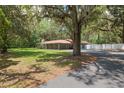 Expansive lot with mature trees surrounding a ranch-style house with red metal roof at 4010 Sw 7Th Avenue Rd, Ocala, FL 34471