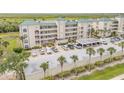 Condo building exterior with palm trees and parking spaces at 420 Bouchelle Dr # 204, New Smyrna Beach, FL 32169