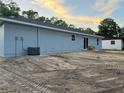 Rear exterior view of a home with a new roof, light grey paint and level backyard at 5787 Nw 58Th Ter, Ocala, FL 34482