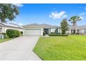 Beautiful single-story home with green lawn, palm trees and a two-car garage at 6651 Sw 93Rd Ct, Ocala, FL 34481