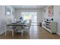 Bright dining room with modern table, chairs, console, and sliding glass doors at 8622 Baylor Cir, Orlando, FL 32817