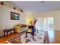 Bright living room featuring a cozy sofa, area rug, and sliding glass doors to the outside at 9325 Sw 125Th Court Rd, Dunnellon, FL 34432