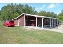 Exterior view of the covered area, with a golf cart parked inside at 9430 Sw 102Nd Pl, Ocala, FL 34481