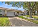 View of charming home with a long driveway, attached garage, and front porch area at 9667 Sw 94Th Ct # C, Ocala, FL 34481